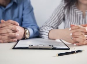Couple with divorce contract and ring on desk. Divorce